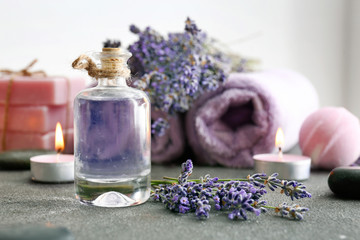 Obraz na płótnie Canvas Bottle of lavender essential oil on grey table