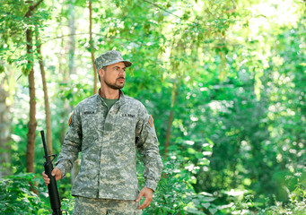 Obraz premium Soldier with assault rifle in forest