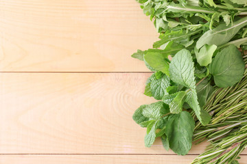 Different fresh herbs on wooden table