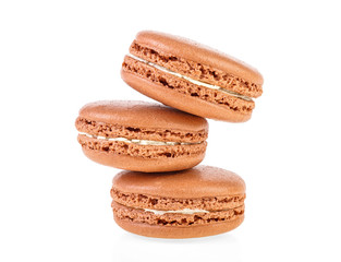Three brown macaroons on a white background