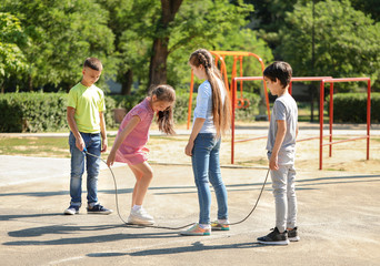 Cute little children jumping rope on playground © Pixel-Shot