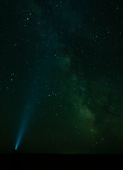Torch light pointing to the Milky Way - Gobi Desert, Mongolia