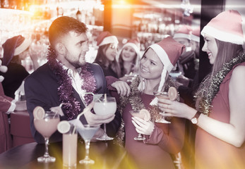 Fototapeta na wymiar Guy with girls on new year eve party in bar