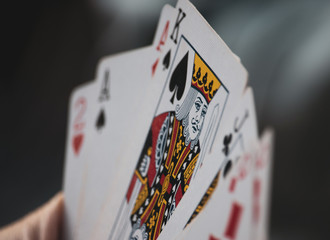 Perspective of hand of cards with king of spades in focus