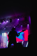 Baixista, silhueta e luzes do palco