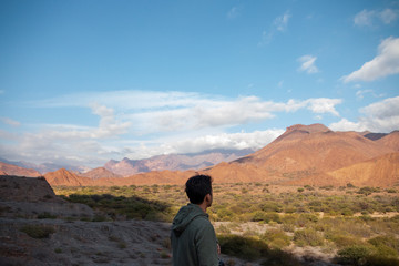 Fototapeta premium Hombre joven moreno mirando a la inmensidad de la naturaleza en soledad y quietud 