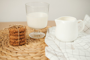 oatmeal cookies with milk on a wicker napkin on the table