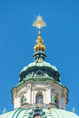 Golden Eye of Providence at the dome roof of St. Nicholas Church in Prague, Czech Republic blue...
