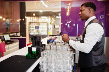 African american bartender at bar pouring from tap fresh beer into the glass in pub.