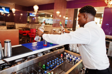 Fototapeta premium African american bartender working behind the cocktail bar. Alcoholic beverage preparation.