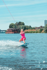 Fit Caucasian attractive wakeboarder in a pink outfit looking straight ahead