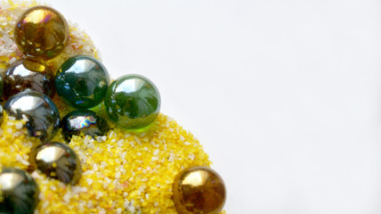 bright background beautiful colorful glass balls in yellow with pink and white sand