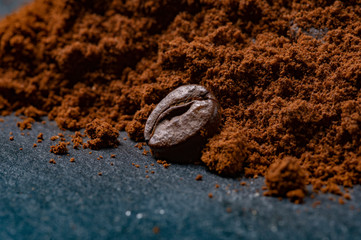 Coffee grain lying next to ground coffee