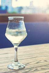 A glass of cold white wine on the table on the terrace of a summer cafe