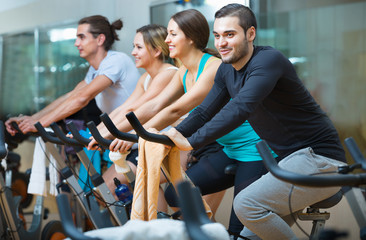 Group smiling  working out of cycling in  fitness club