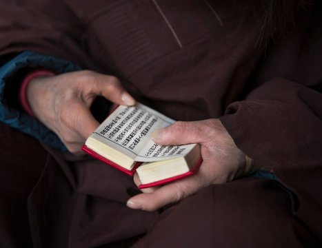 Close up of man holding prayer book