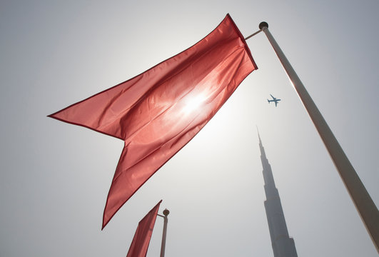 Low Angle View Of Red Flag Waving Against Clear Sky