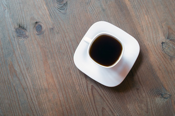 cup of coffee on wooden background. Beautiful white cup, stylish toning, place for text. Cup of black tea on wooden background. cheerful morning concept. Top view