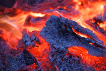 Abstract background of burning coals. Smoldering embers of fire at night. Texture bonfire heat embers.