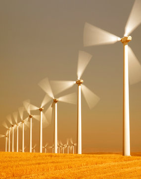 View of wind turbines spinning in field