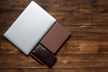 work space of a businessman. view from above . coffee notebook and laptop on the desktop with black note.