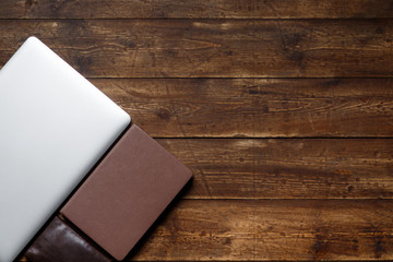 work space of a businessman. view from above . coffee notebook and laptop on the desktop with black note.