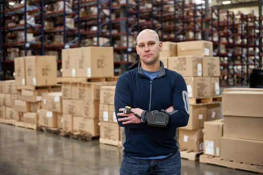 Portrait of man with barcode reader standing in distribution warehouse
