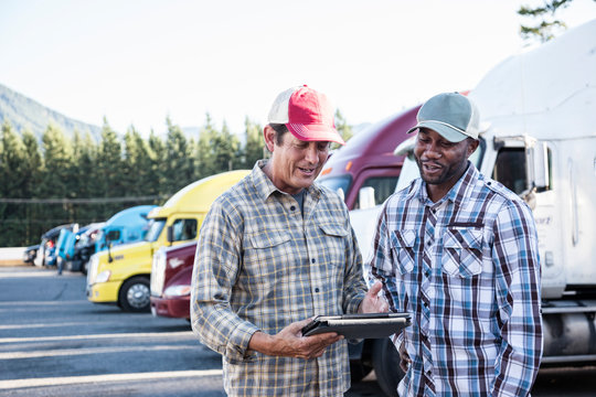 Truck drivers using digital tablet at truck stop