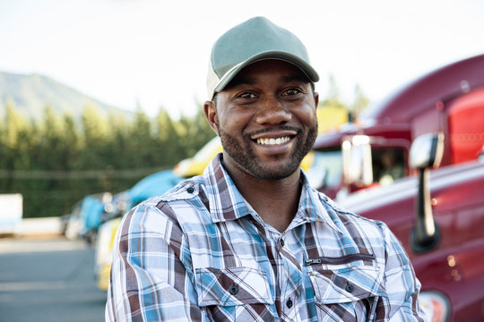 Portrait of truck driver standing at truck stop