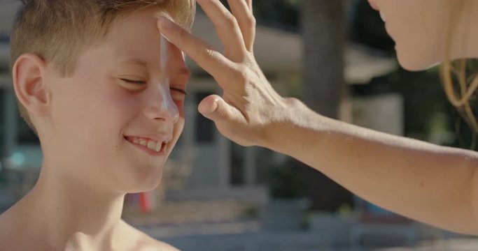 mother applying suntan lotion on little boys skin for sun protection happy kid getting ready to swim in pool with mom using sunscreen caring for childs health on sunny day 4k