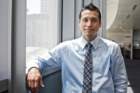 Portrait Of Businessman Standing In Office Lobby