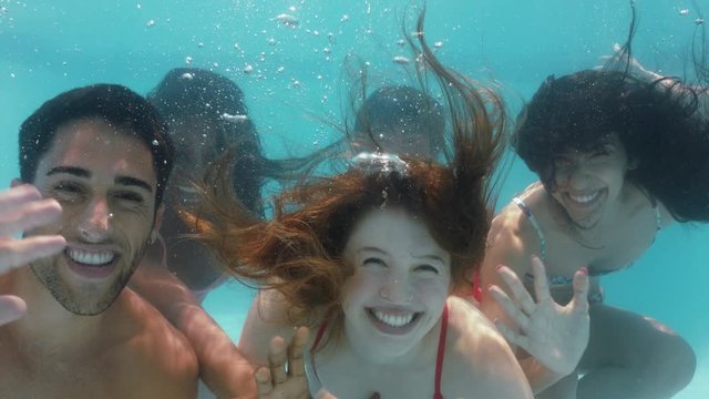cool friends swimming underwater in pool waving having fun celebrating summer vacation together enjoying spring break pool party 4k