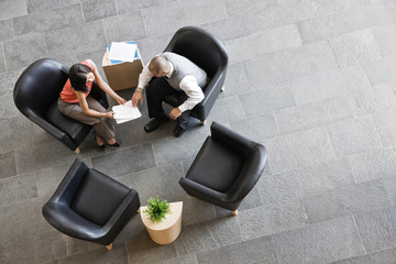 Overhead view of business people sitting on chair in office lobby