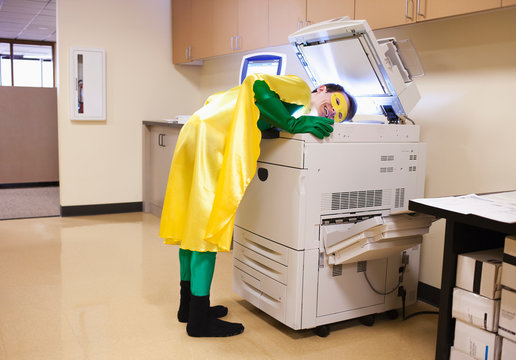 Businessman in super hero costume making copy of his head