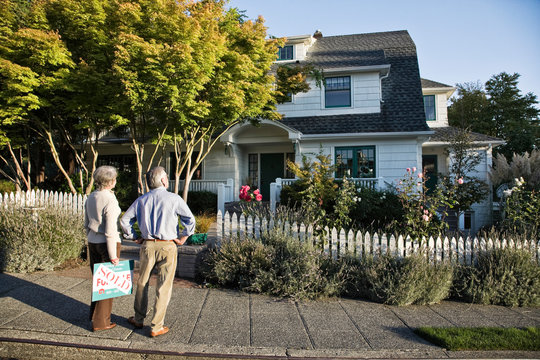Rear view of couple looking at new home