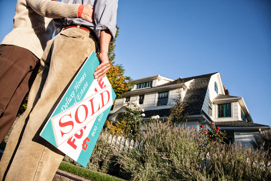 Low section of couple standing outside new home