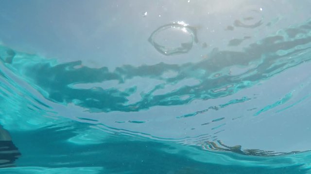 swimming pool underwater view of crystal clear water with bright sunlight shining on surface 4k footage