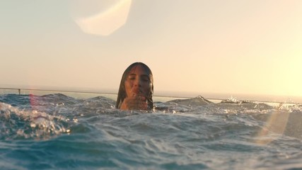group of friends in swimming pool splashing playfully enjoying summer vacation having fun celebrating summertime at sunset 4k