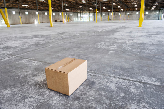 Cardboard box in middle of empty warehouse