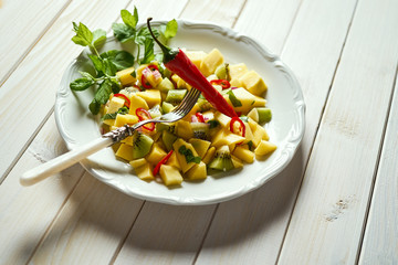 Fresh organic colorful salad with melon on white wooden table