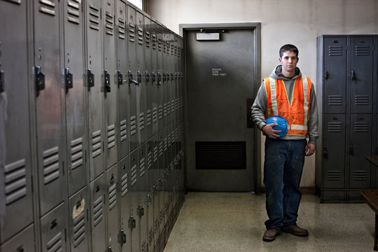 Portrait of young worker standing in locker room