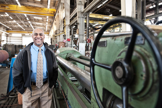Portrait of smiling manager standing in factory