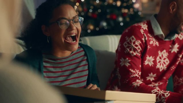 christmas gift woman opening present with surprise sexy underwear laughing enjoying funny joke with friends and family celebrating festive holiday at home 4k