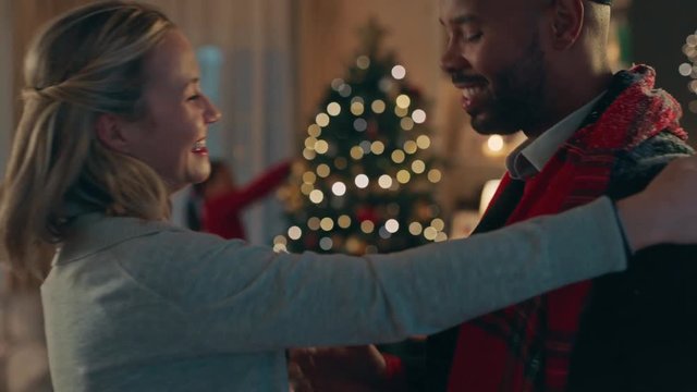 african american man visiting friend for christmas eve hugging bringing presents for happy woman enjoying festive holiday celebration together on winter evening at home 4k footage