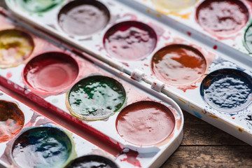 close up view of watercolor paint palettes on wooden table