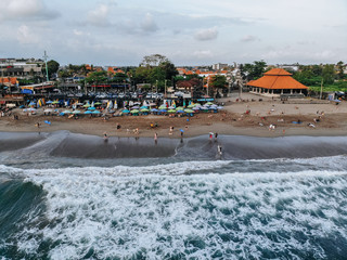 Canggu, Bali, Indonesia - Feb 15 2019: Aerial view of Canggu beach with surfers and umbrellas located in the west of Bali