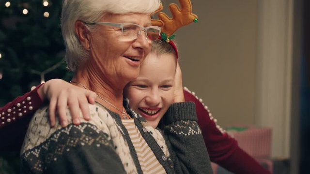 happy girl hugging grandmother at christmas eve dinner party enjoying family celebration with granny 4k footage