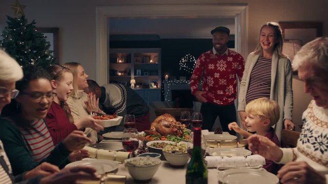 happy family enjoying christmas dinner party eating delicious food at festive celebration sitting at table with friends arriving celebrating holiday at home 4k footage