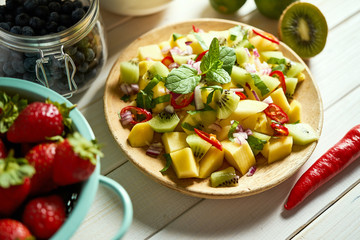 Fresh organic colorful salad of melon with chili on white table