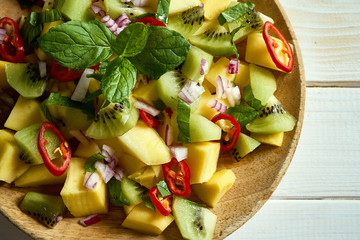 Fresh organic colorful salad with melon on white wooden table